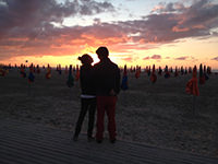 un couple d'amoureux devant un coucher de soleil sur les planches